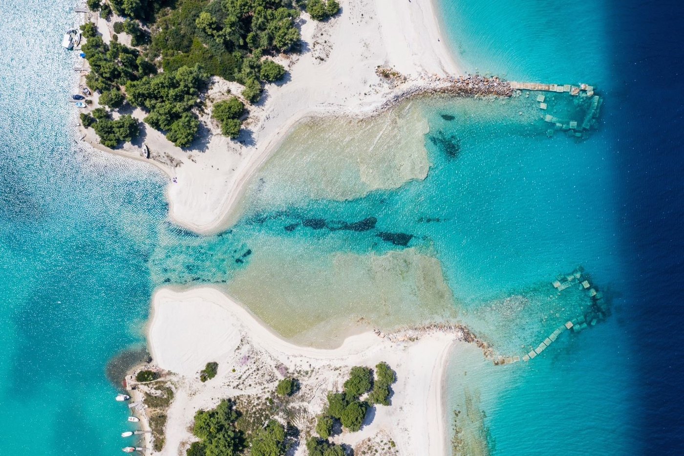 Aerial photograph of the Glarokavos Beach lagoon in Paliouri — turquoise water, pale sand and green coastline.